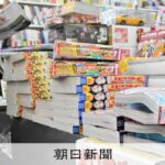 開店前、取次が運んできた雑誌を店頭に並べる書店員